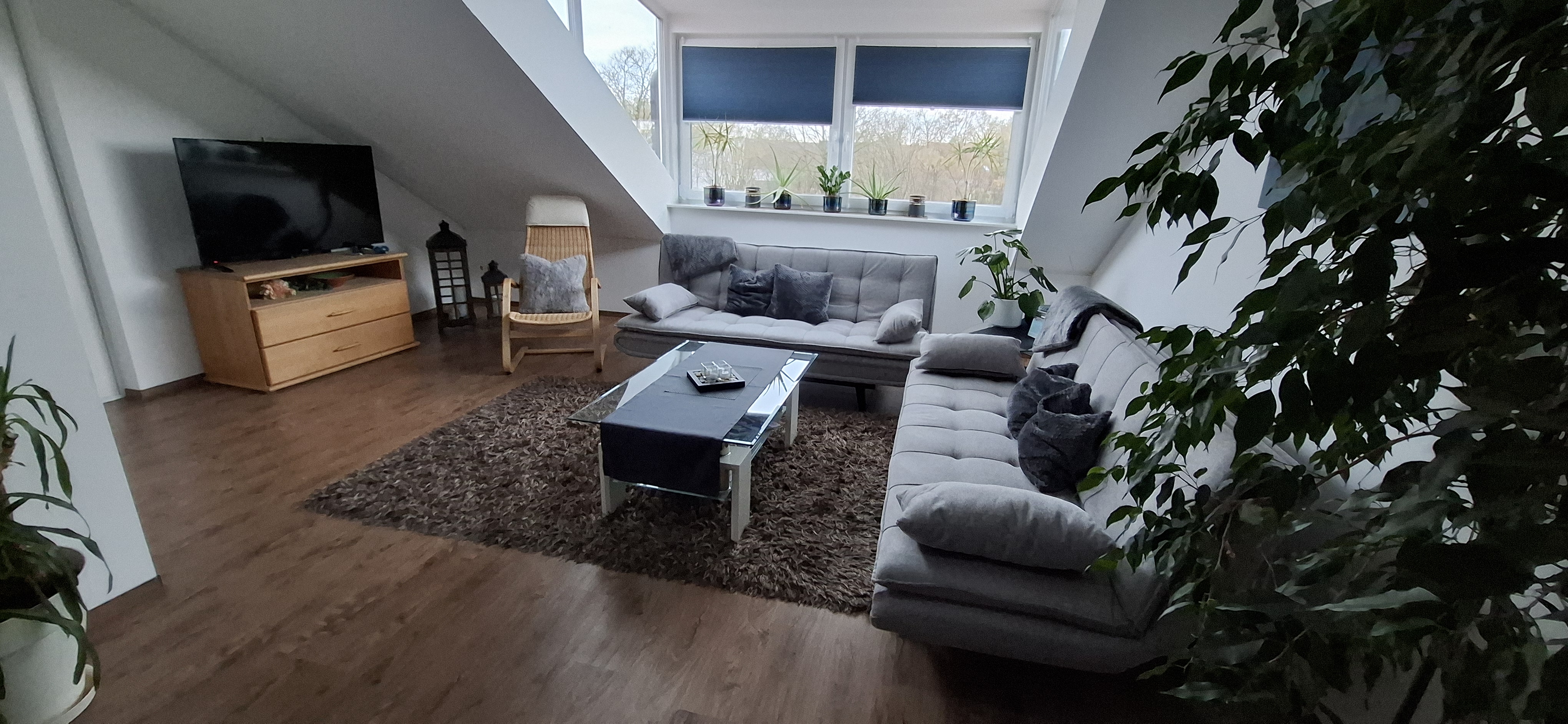 Helles Wohnzimmer mit gemütlicher Sofa Ecke und Smart-TV